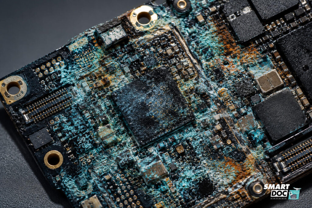 Smartphone-Mainboard mit starker grüner Korrosion und Oxidation nach Wasserschaden, Nahaufnahme aus der SmartDoc Erfurt Werkstatt