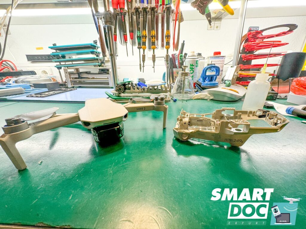 Reparierte DJI Mini 2 nach Rahmentausch bei SmartDoc Erfurt neben dem ausgebauten Mittelrahmen